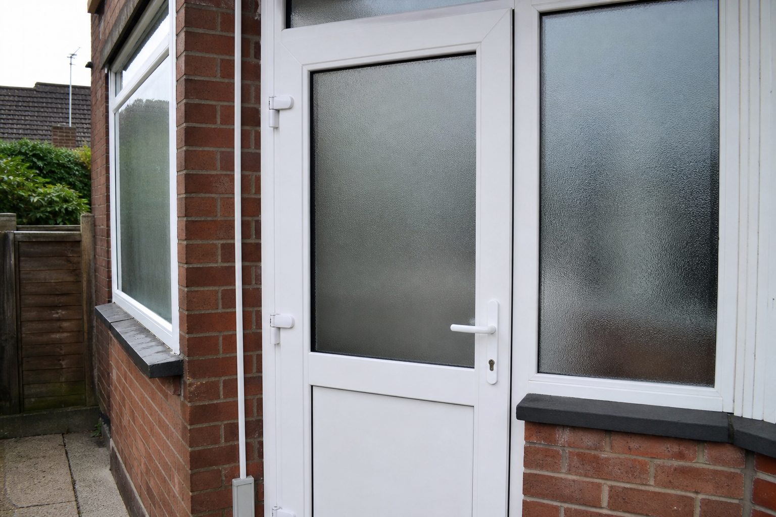 Repaired white uPVC porch door with frosted glazing and new hinges